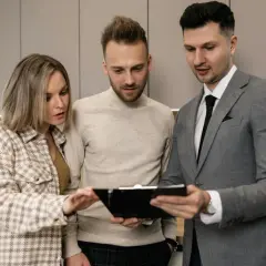 Para omawia z agentem nieruchomości dokumenty dotyczące dopłat do wynajmu mieszkania.