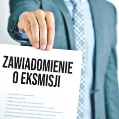 Mężczyzna w garniturze trzyma dokument z napisem "Zawiadomienie o eksmisji", sugerujący wstrzymanie eksmisji z mieszkania.
