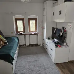 Pokój z łóżkiem, szafami i telewizorem. Idealne miejsce, by zamienię mieszkanie własnościowe na mniejsze.