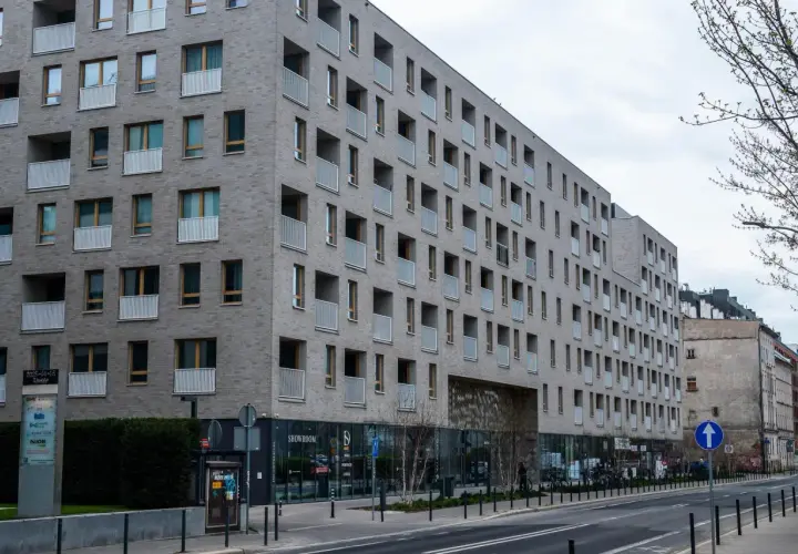 Nowoczesny budynek mieszkalny z balkonami. Zastanawiasz się, jak sprawdzić, czy mieszkanie jest zadłużone? Warto sprawdzić księgę wieczystą.