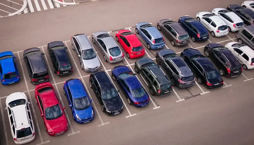 Wspólnota mieszkaniowa pilnuje porządku, by uniknąć mandatu za parkowanie. Wiele samochodów na parkingu.