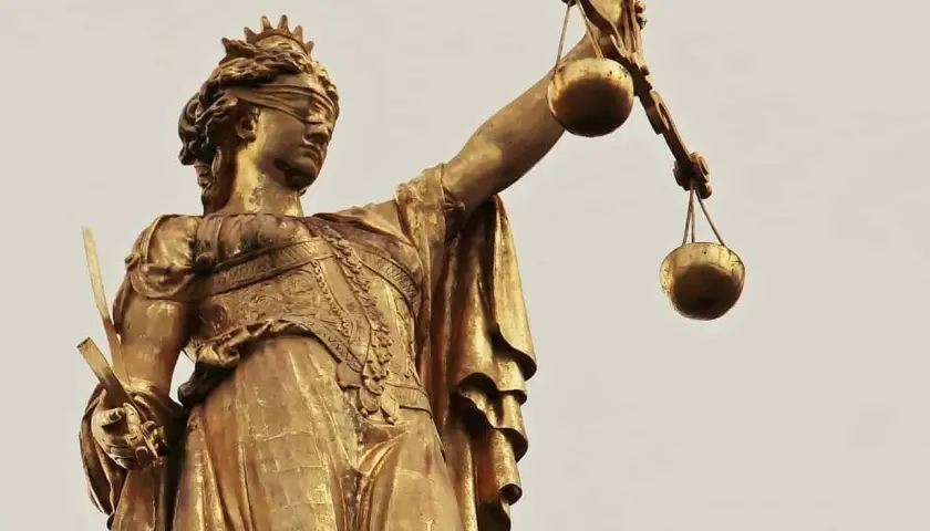 Złota statua Temidy z przepaską na oczach i wagą w dłoni, symbol sprawiedliwości, która może być utrudnianie korzystania z lokalu.