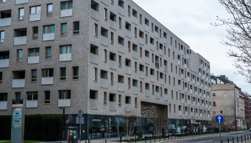 Nowoczesny budynek mieszkalny z balkonami. Zastanawiasz się, jak sprawdzić, czy mieszkanie jest zadłużone? Warto sprawdzić księgę wieczystą.