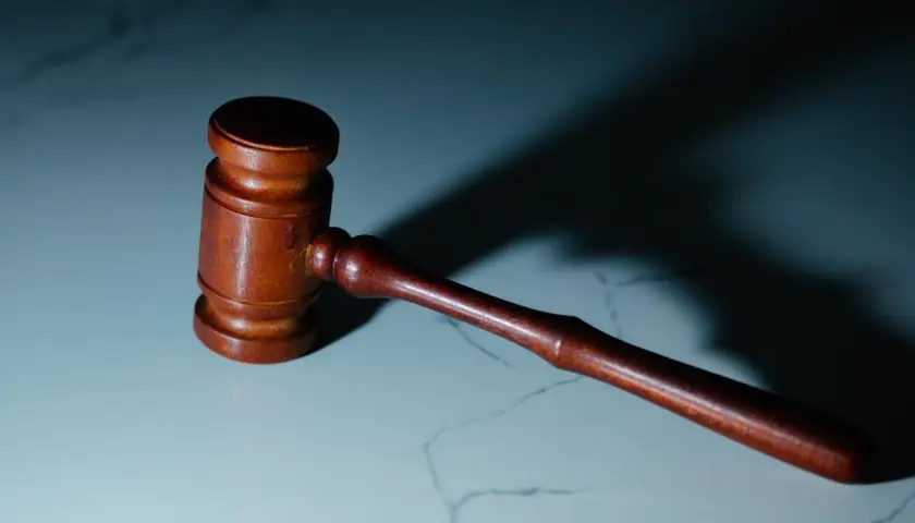 Młotek sędziowski na marmurowym blacie. Czy syndyk może sprzedać mieszkanie z lokatorem? Pytanie o prawa lokatorów w postępowaniu upadłościowym.