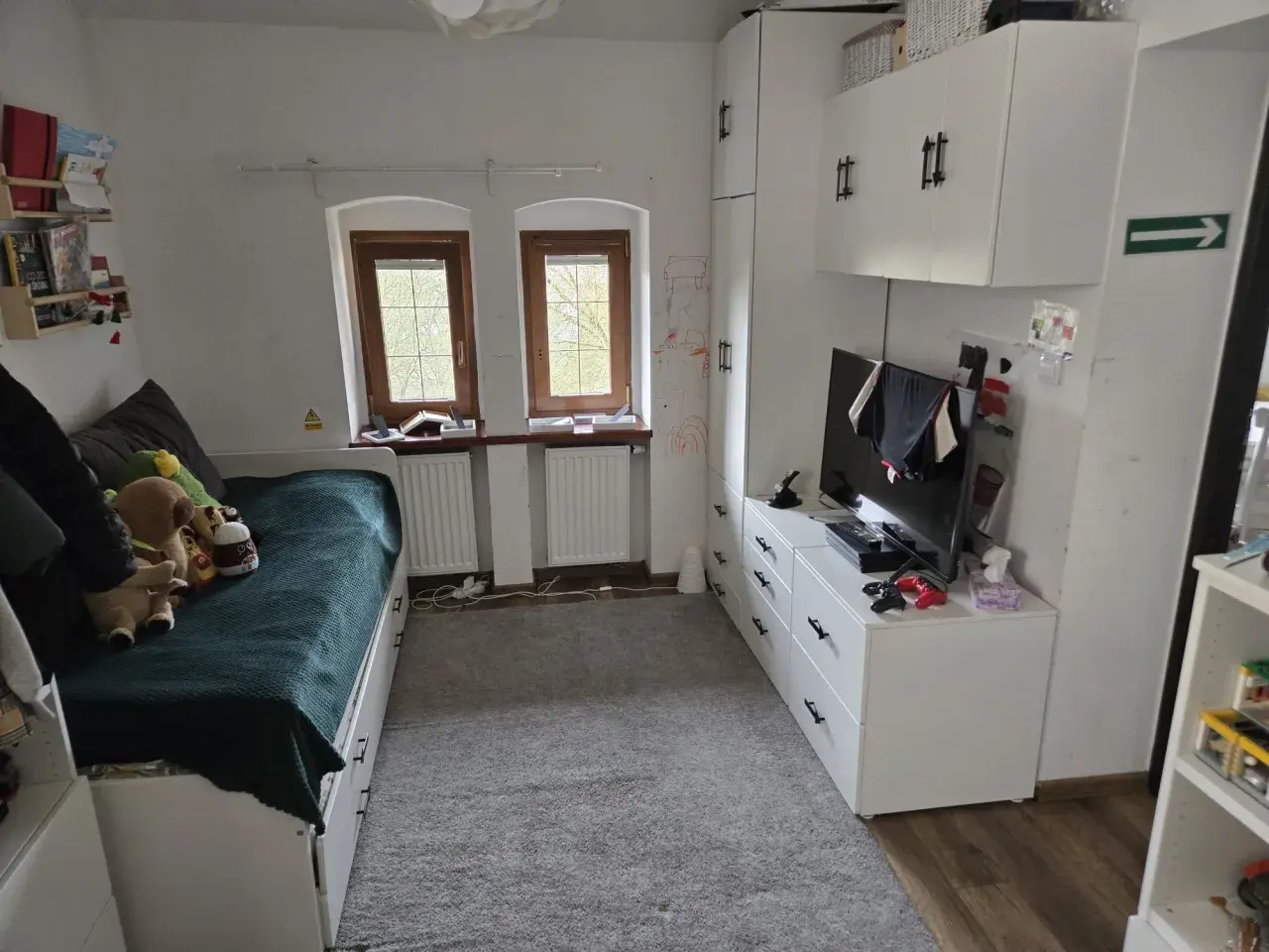 Pokój z łóżkiem, szafami i telewizorem. Idealne miejsce, by zamienię mieszkanie własnościowe na mniejsze.